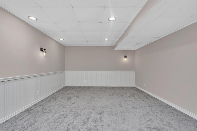 empty room with a paneled ceiling and carpet floors