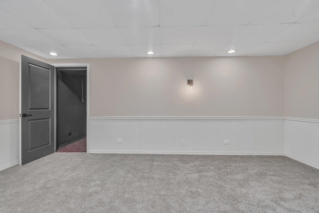 basement featuring carpet flooring and a drop ceiling