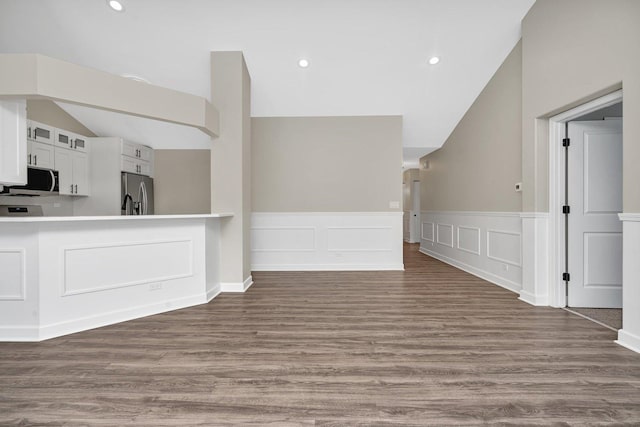 unfurnished living room with hardwood / wood-style flooring and vaulted ceiling