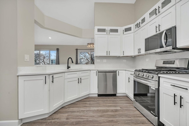 kitchen with white cabinetry, sink, stainless steel appliances, and light wood-type flooring