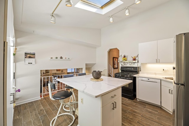 kitchen featuring white cabinetry, a center island, black range with gas stovetop, white dishwasher, and a kitchen breakfast bar