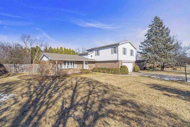 split level home featuring a garage and a front lawn