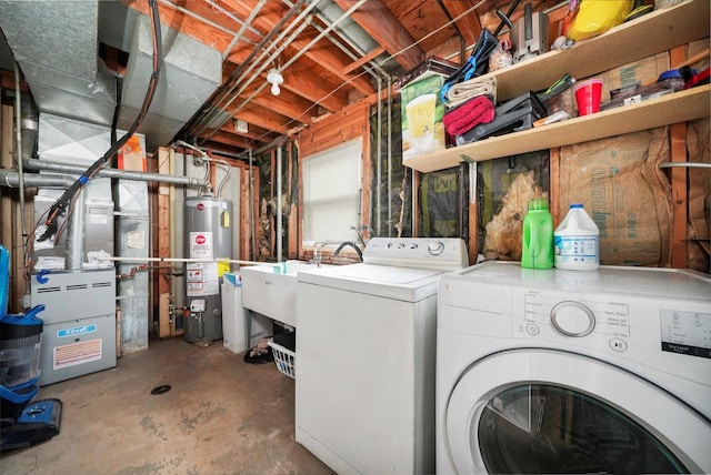 clothes washing area featuring gas water heater, separate washer and dryer, and sink