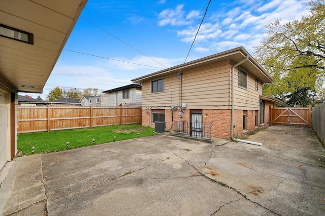 rear view of property with a patio, cooling unit, and a lawn