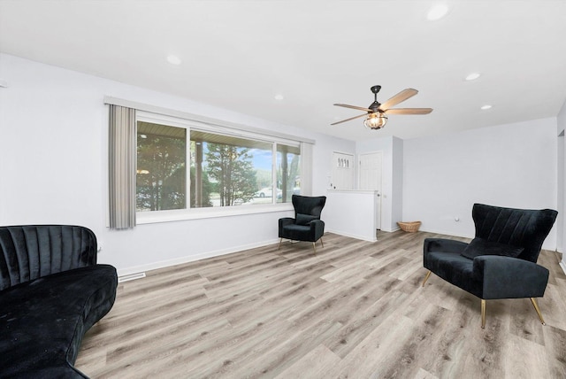 living area featuring light hardwood / wood-style floors and ceiling fan