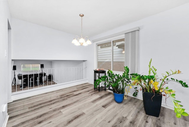 dining area with a notable chandelier, a wealth of natural light, and wood-type flooring