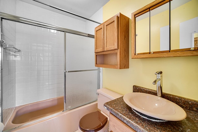 full bathroom featuring enclosed tub / shower combo, vanity, and toilet