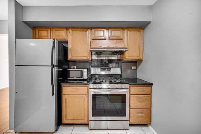 kitchen with backsplash, light tile patterned floors, and appliances with stainless steel finishes