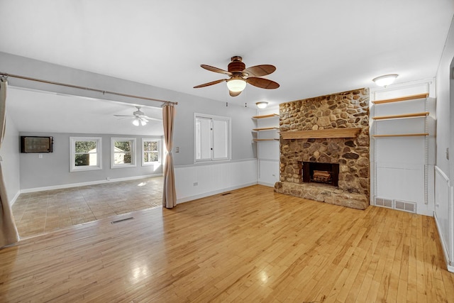 unfurnished living room with light hardwood / wood-style flooring, a fireplace, and ceiling fan