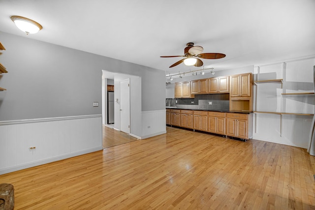 kitchen with tasteful backsplash, stainless steel fridge, ceiling fan, track lighting, and light hardwood / wood-style flooring