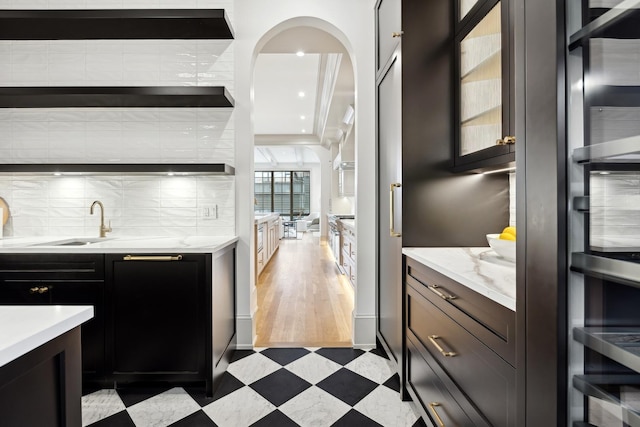 kitchen featuring light stone countertops, sink, and decorative backsplash