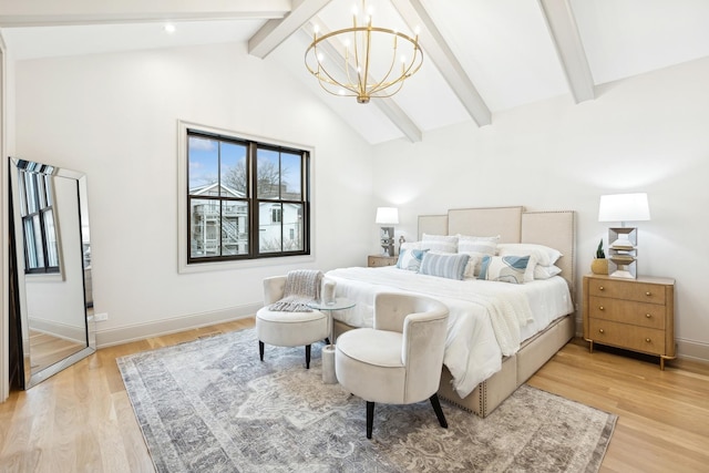 bedroom with lofted ceiling with beams, a chandelier, and light hardwood / wood-style floors