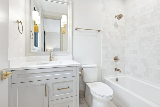 full bathroom featuring tiled shower / bath, vanity, and toilet