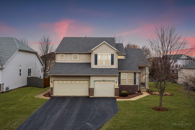 view of front of property featuring a garage and a lawn