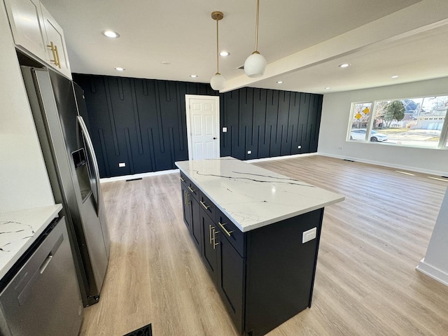 kitchen featuring white cabinetry, hanging light fixtures, a center island, light stone counters, and stainless steel fridge with ice dispenser