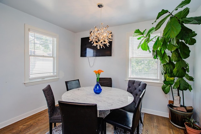 dining area with an inviting chandelier and dark wood-type flooring