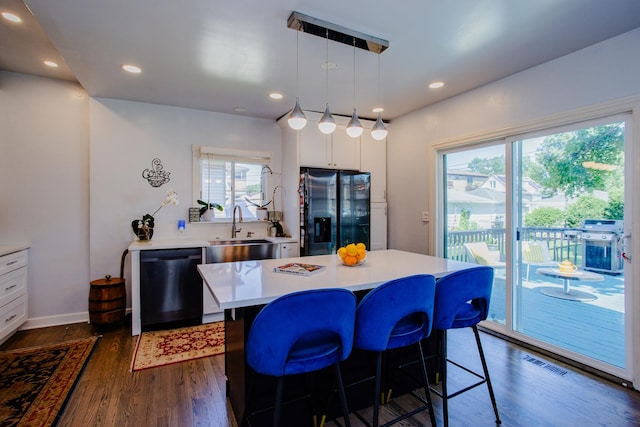 kitchen featuring hanging light fixtures, a kitchen island, white cabinets, and black appliances