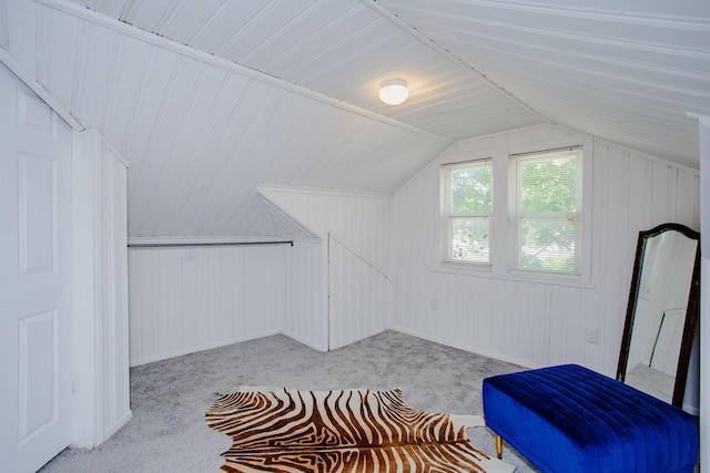 additional living space featuring vaulted ceiling and light colored carpet