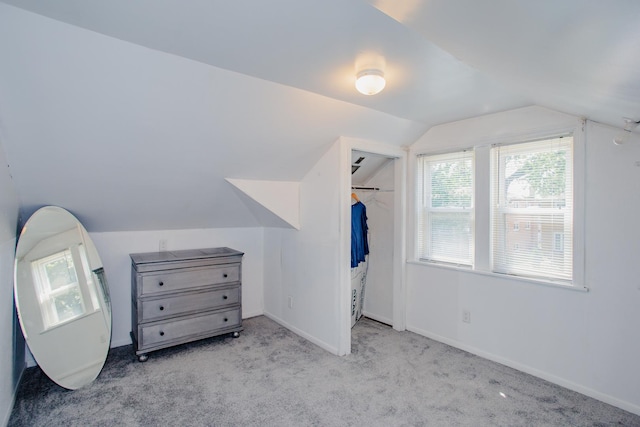 additional living space featuring lofted ceiling and light carpet