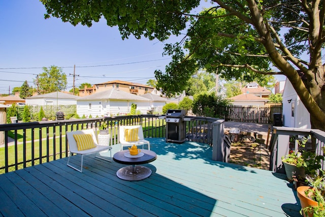 deck featuring grilling area and a lawn