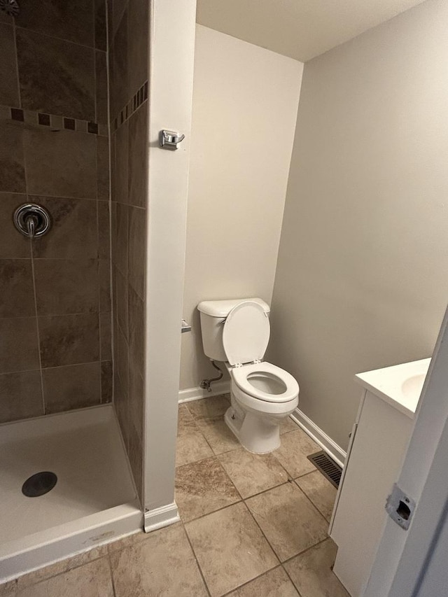 bathroom featuring vanity, toilet, and tiled shower