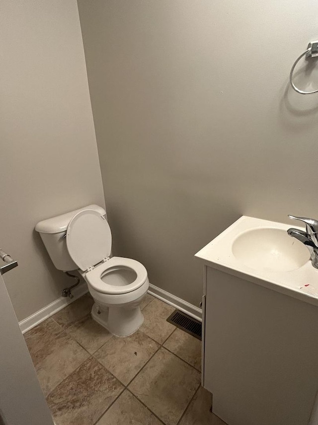 bathroom with tile patterned flooring, vanity, and toilet