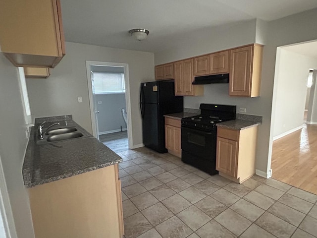 kitchen with light tile patterned floors, sink, and black appliances