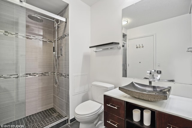 bathroom featuring vanity, walk in shower, and toilet