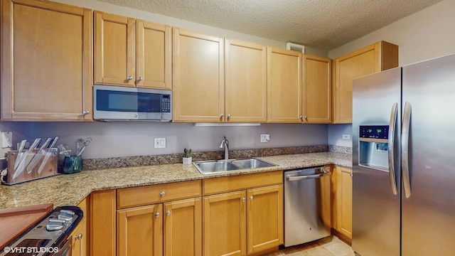 kitchen featuring sink, stainless steel appliances, a textured ceiling, and light stone countertops