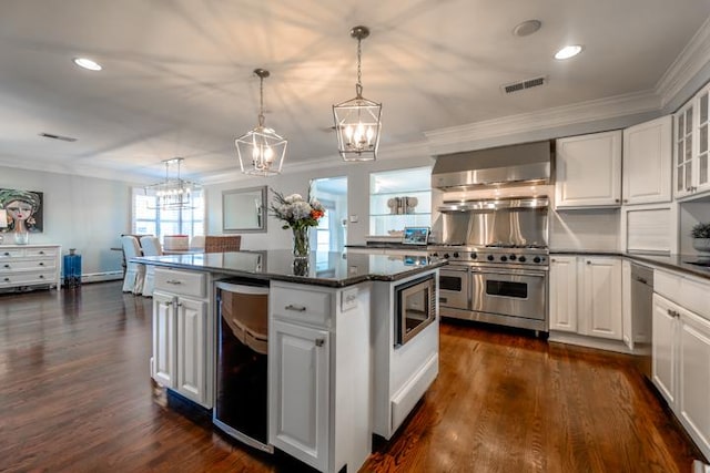 kitchen featuring white cabinetry, pendant lighting, appliances with stainless steel finishes, and wall chimney range hood