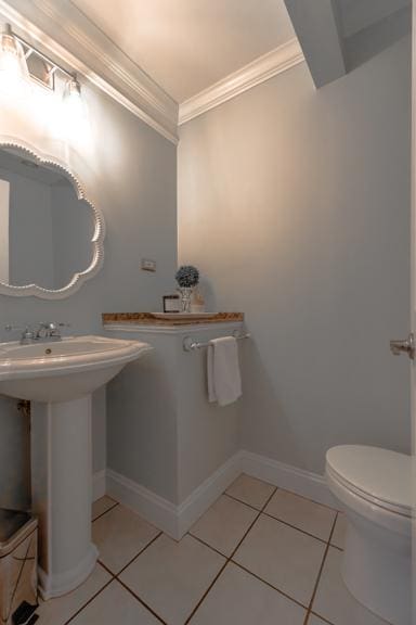 bathroom featuring tile patterned flooring, ornamental molding, and toilet