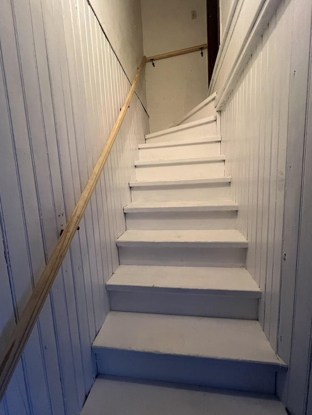 stairs featuring wood walls