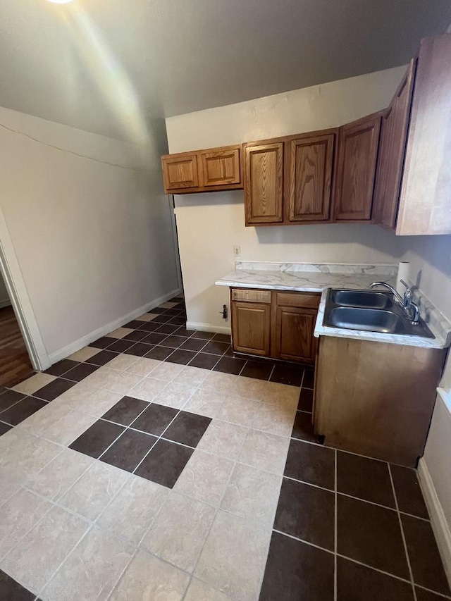 kitchen featuring sink and dark tile patterned floors