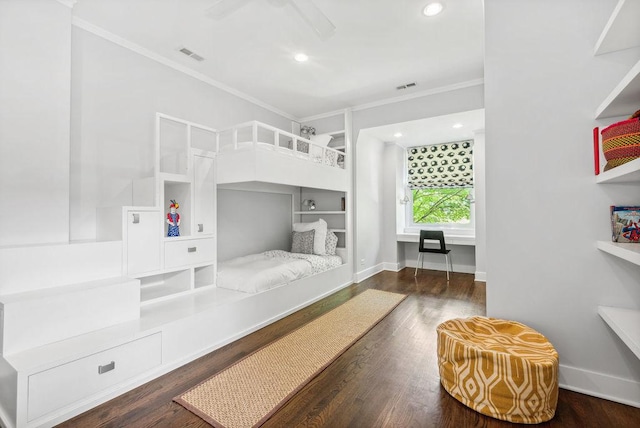 bedroom featuring crown molding, built in desk, and dark wood-type flooring