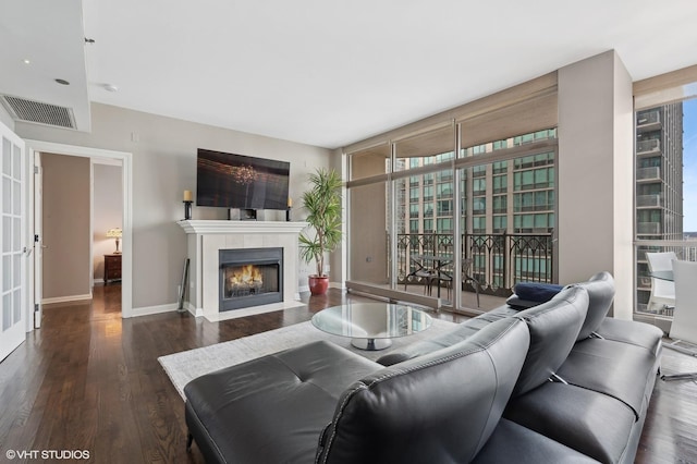 living room with floor to ceiling windows and dark hardwood / wood-style flooring