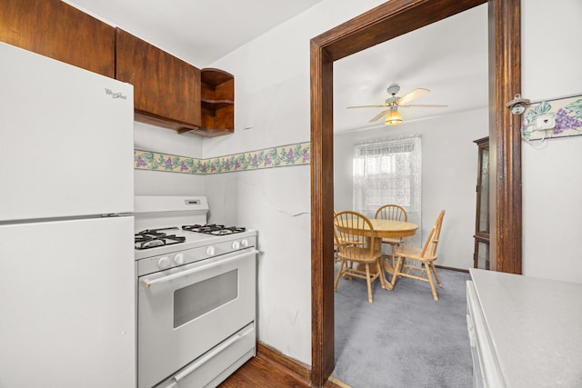 kitchen with dark colored carpet, ceiling fan, and white appliances