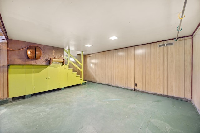 basement featuring wood walls