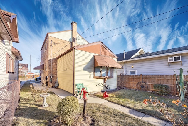 back of property with a lawn and a wall mounted AC