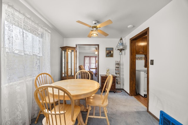 dining area featuring light carpet and ceiling fan