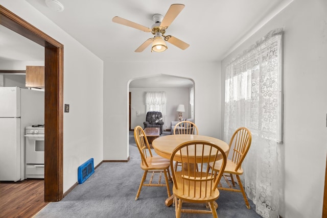 carpeted dining area featuring ceiling fan