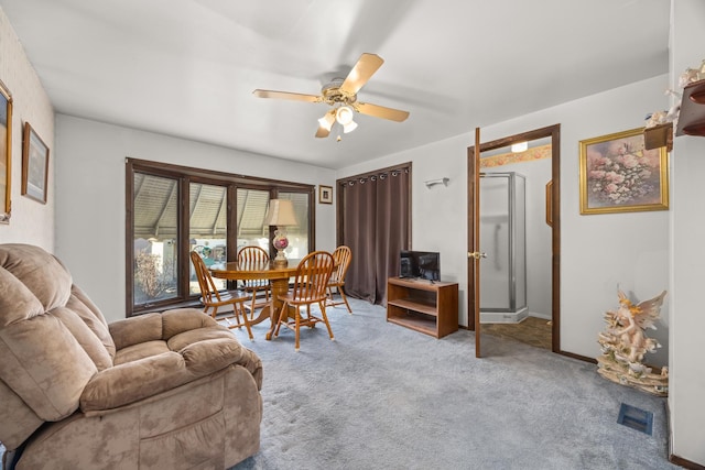 carpeted dining area with ceiling fan