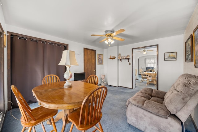 carpeted dining space featuring ceiling fan