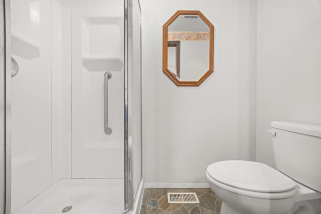 bathroom with toilet and a shower with shower door