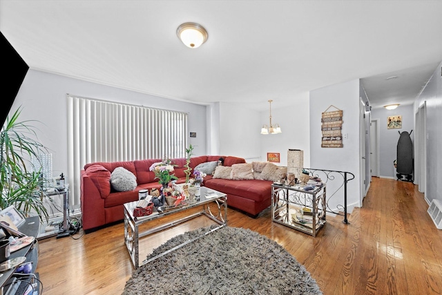 living room featuring an inviting chandelier and wood-type flooring