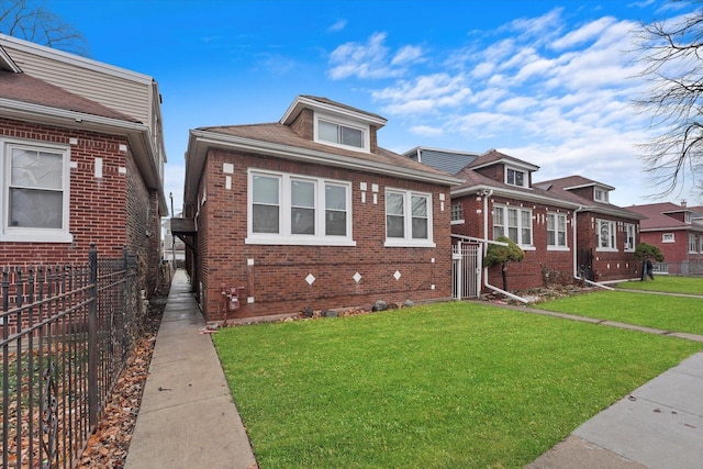 view of front of house with brick siding, fence, and a front yard