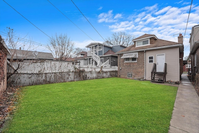 view of yard featuring entry steps and fence