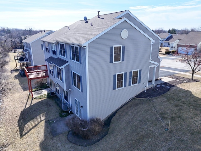 view of side of home featuring a wooden deck and central AC