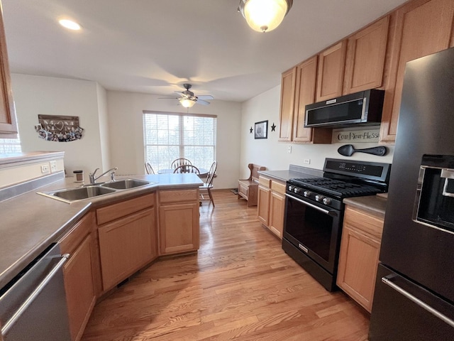 kitchen with appliances with stainless steel finishes, sink, light brown cabinetry, and light hardwood / wood-style floors