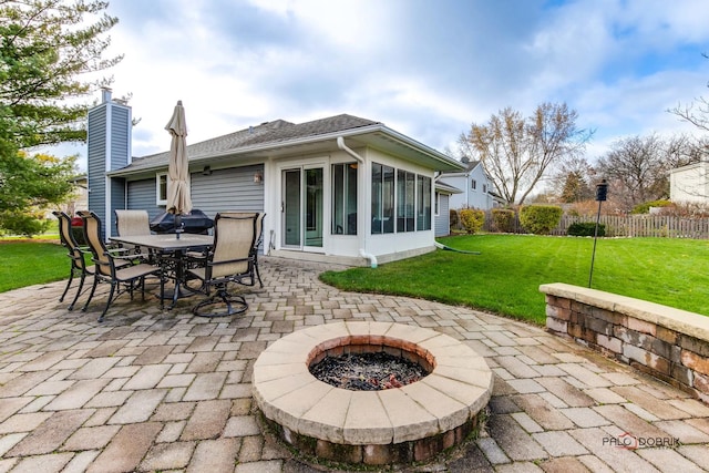 view of patio / terrace with a sunroom and a fire pit