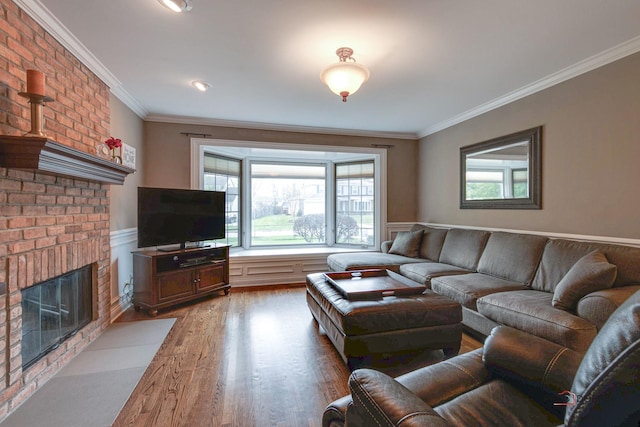 living room with crown molding, a fireplace, and light hardwood / wood-style floors